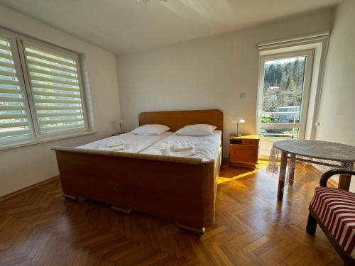 a bedroom with a bed and a table and windows at Myśliwska 23 - Cały dom na wyłączność in Szczyrk