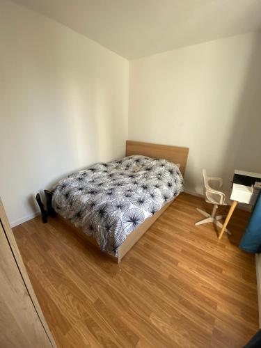 une chambre avec un lit et un parquet dans l'établissement Cosy flat near Parc des Princes, à Boulogne-Billancourt