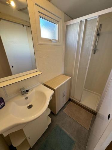 une salle de bain avec un lavabo, des toilettes et une douche dans l'établissement Mobilhome 3 chambres 6 personnes près de la plage - Novela - Frédéric et Sandra, à Port-la-Nouvelle