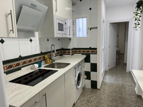 een keuken met een spoelbak en een wasmachine bij Sweet Home Center Beatas in Málaga