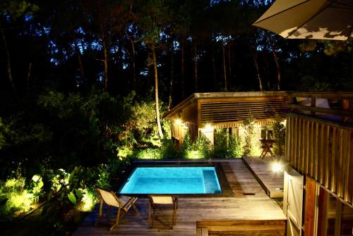 une arrière-cour avec une piscine la nuit dans l'établissement Villa avec piscine chauffée à la pointe, à Lège-Cap-Ferret
