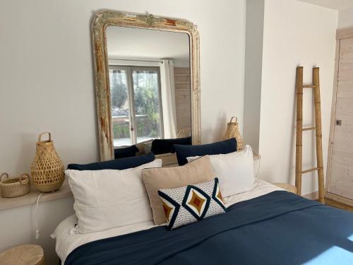 - une chambre avec un lit doté d'un miroir et d'oreillers dans l'établissement Villa avec piscine chauffée à la pointe, à Lège-Cap-Ferret