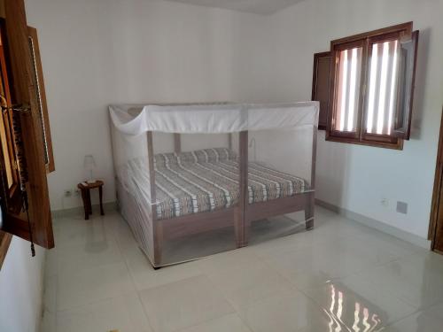 a bed with a canopy in a room at Ker Vento in Rufisque