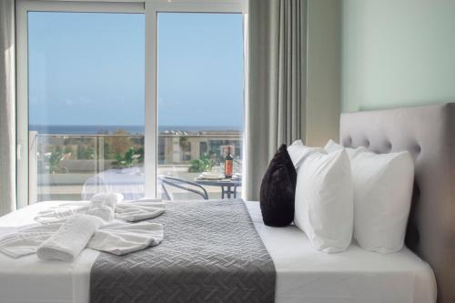 a bedroom with a bed with white pillows and a window at Kolymvari Hills in Chania Town