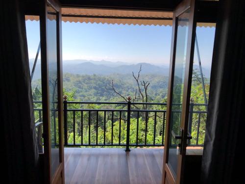 a room with a balcony with a view of the mountains at Eagle View villa in Ella