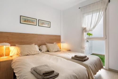 sypialnia z dużym łóżkiem z ręcznikami w obiekcie Apartamento María Conil Bajo w mieście Conil de la Frontera