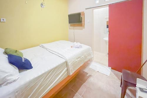 a small bedroom with a bed and a shower at Urbanview Hotel Sany Cirebon in Tangkil