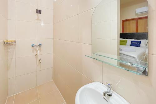 a bathroom with a sink and a mirror and a toilet at Urbanview Hotel Sany Cirebon in Tangkil