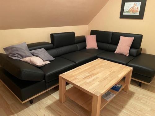 ツィングストにあるHaus Marleen OG, FW 2の黒革のソファ(枕付)、コーヒーテーブルが備わります。