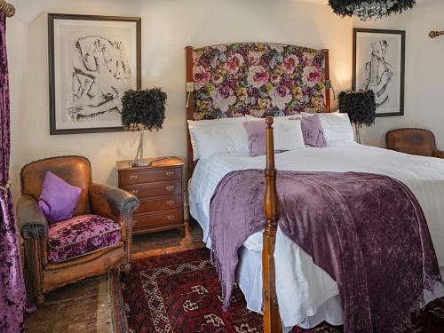 a bedroom with a bed and a chair at Thorn Cottage Winsford in Winsford