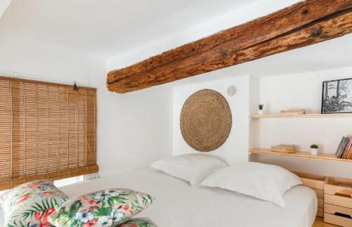 - une chambre avec un lit blanc et un plafond en bois dans l'établissement Appartement authentique situé en plein centre d'Antibes, à Antibes
