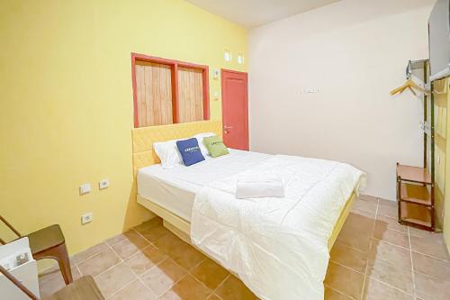 a bedroom with a large white bed in a room at Urbanview Hotel Sany Cirebon in Tangkil