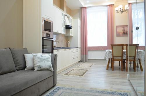 a living room with a couch and a kitchen at Ekskluzywny apartament w pałacu z parkiem Palac Chociule in Świebodzin