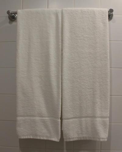 - une serviette blanche suspendue à un porte-serviettes dans la salle de bains dans l'établissement Vegas Residence, à Albufeira