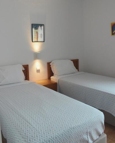 two beds in a hotel room with two beds at Vegas Residence - Adults Only in Albufeira