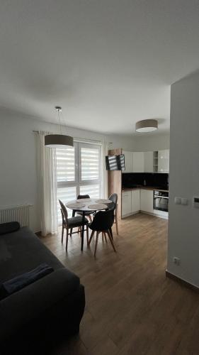 uma sala de estar com mesa e cadeiras e uma cozinha em Falla Apartamenty- ul Wiejska Ustronie Morskie em Ustronie Morskie