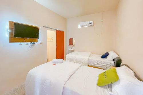 Habitación con 2 camas y TV de pantalla plana. en Urbanview Hotel Sany Cirebon en Tangkil