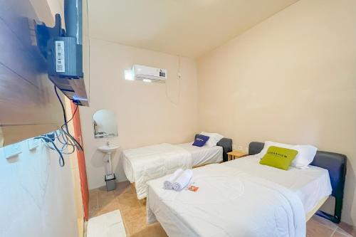 a hospital room with two beds and a tv at Urbanview Hotel Sany Cirebon in Tangkil