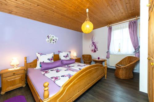 ein Schlafzimmer mit einem Holzbett mit violetter Bettwäsche in der Unterkunft Ferienwohnung Spitzner in Störnstein