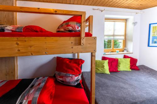 two bunk beds in a room with red and green pillows at Ferienwohnung Spitzner in Störnstein