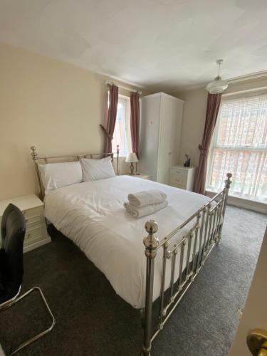 um quarto com uma cama grande e lençóis brancos em 62 Sturry Road em Canterbury