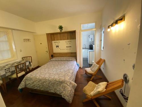 a bedroom with a bed and a table and a kitchen at Departamento Mar del Plata in Mar del Plata