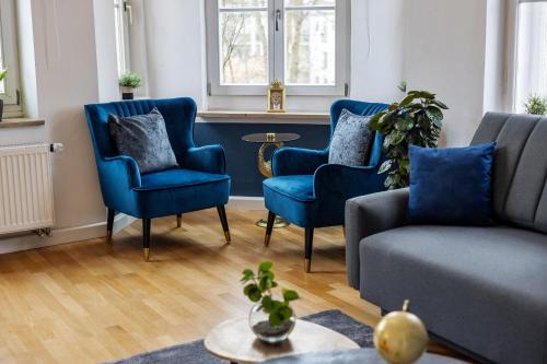 ein Wohnzimmer mit blauen Stühlen und einem Sofa in der Unterkunft apart21 - Exklusive Apartments in zentraler Lage mit Parkplatz in Ingolstadt