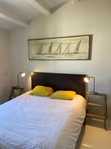 - une chambre avec un lit et 2 oreillers jaunes dans l'établissement Maison proche de la plage, à La Couarde-sur-Mer