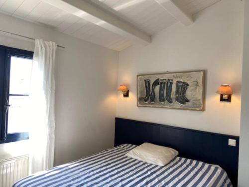 une chambre avec un lit et un tableau au mur dans l'établissement Maison proche de la plage, à La Couarde-sur-Mer