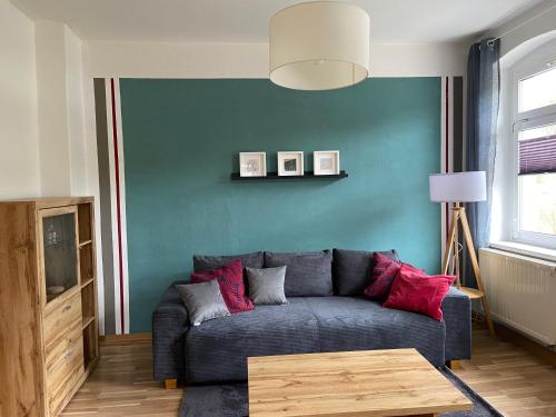 sala de estar con sofá y pared azul en Ferienwohnung Fam. Falk, en Zeulenroda