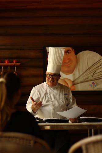 a man wearing a chef hat standing in a kitchen at Aldeia Flor de Liz - Pedra Azul in Pedra Azul