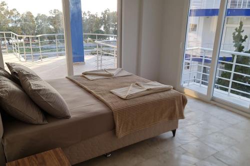 a bed in a room with a large window at White Bay Resort in Didim