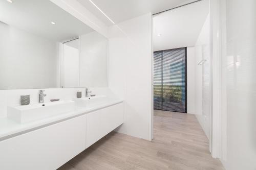 ein weißes Badezimmer mit einem Waschbecken und einem Spiegel in der Unterkunft Villa Natureza in Serra do Bouro