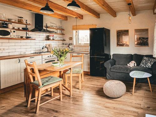 a kitchen and living room with a table and a couch at Chatka Biesczadersko in Lutowiska