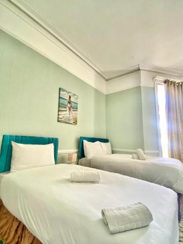 a room with two beds and a window at The Carlton Hotel in Folkestone