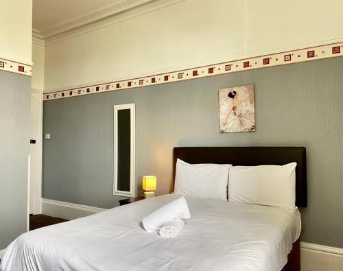 a bedroom with a large white bed with two pillows at The Carlton Hotel in Folkestone