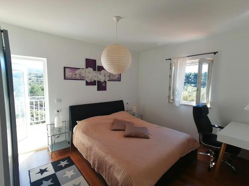 a bedroom with a bed and a desk and windows at Lovely 2-bedroom apartment Lavender in Milna