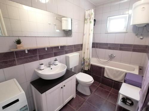 a bathroom with a sink and a toilet and a tub at Lovely 2-bedroom apartment Lavender in Milna