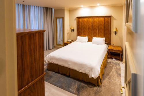 a bedroom with a large bed with a wooden headboard at City Nest - Michelangelo Towers in Johannesburg
