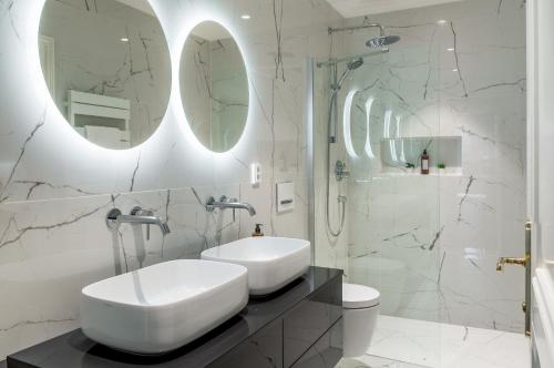 a white bathroom with a sink and a shower at River Dance Suites by Adrez in Prague