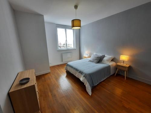 Schlafzimmer mit einem Bett, einem Tisch und einem Fenster in der Unterkunft Appartement cœur de ville in Beauvais