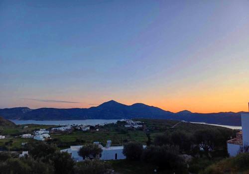 a view of a city and a lake at sunset at Georgia Rooms Milos in Plaka Milou