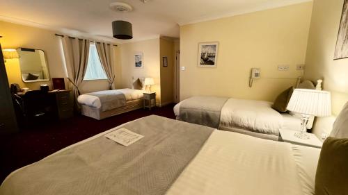 ダブリンにあるワーテルロー ロッジのベッド2台と鏡が備わるホテルルームです。