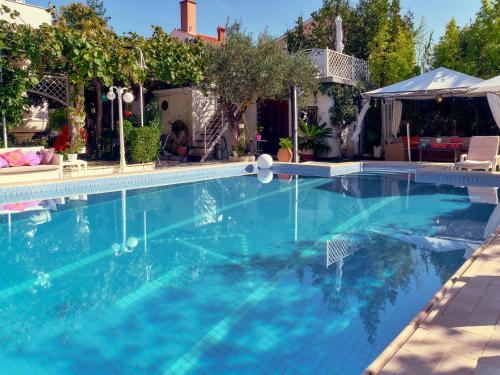 a large swimming pool with blue water at Avalena Residence in Zadar