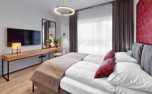- une chambre avec un lit, un bureau et une télévision dans l'établissement Safari Apartment - Plac Wolności 6, à Poznań