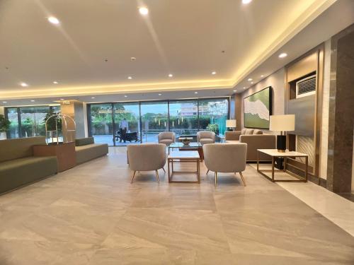a lobby with a table and chairs in a building at SMDC Green 2 Staycation, The Traditional & Modern Fusion Condo in Pasong Bayog