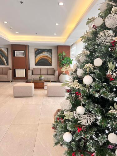 a christmas tree in the lobby of a hotel at SMDC Green 2 Staycation, The Traditional & Modern Fusion Condo in Pasong Bayog