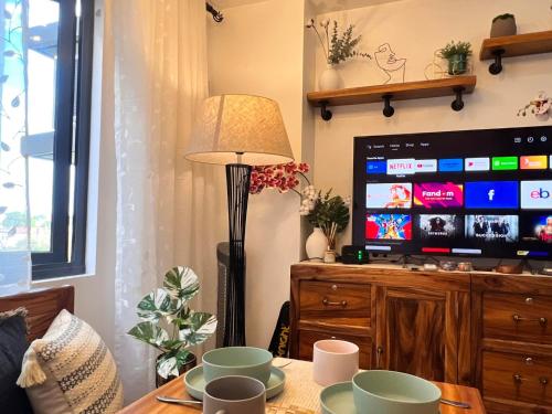 a living room with a table with a lamp and a tv at SMDC Green 2 Staycation, The Traditional & Modern Fusion Condo in Pasong Bayog