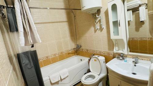 a bathroom with a tub and a toilet and a sink at ORIYO DUSHANBE HOTEL in Dushanbe