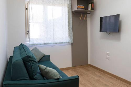 un soggiorno con divano verde e finestra di Appartamento RealValle Verde a Scafati